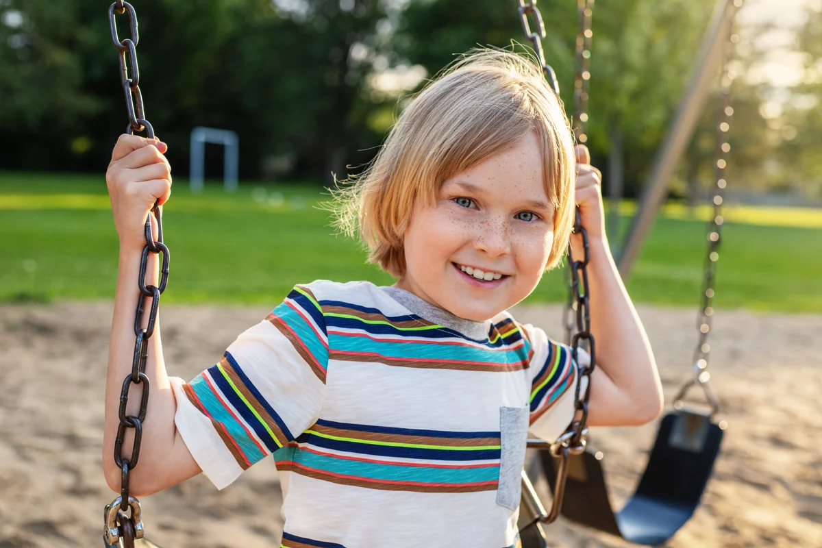A child enjoying a playground swing